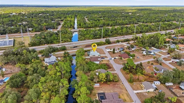 an aerial view of residential houses with outdoor space and trees