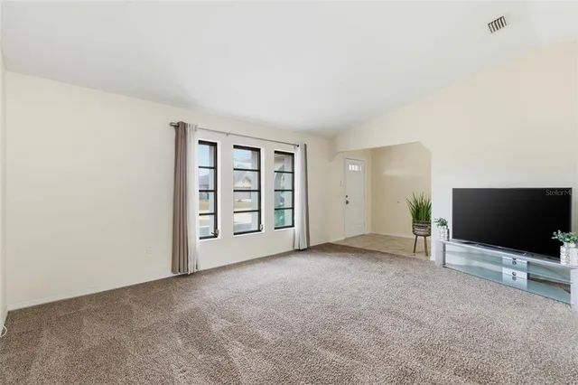 a view of an empty room with a window and cabinet