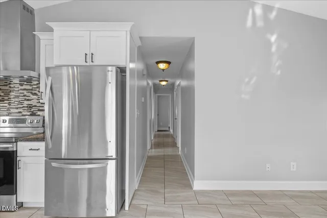 a kitchen with stainless steel appliances granite countertop a sink window and cabinets