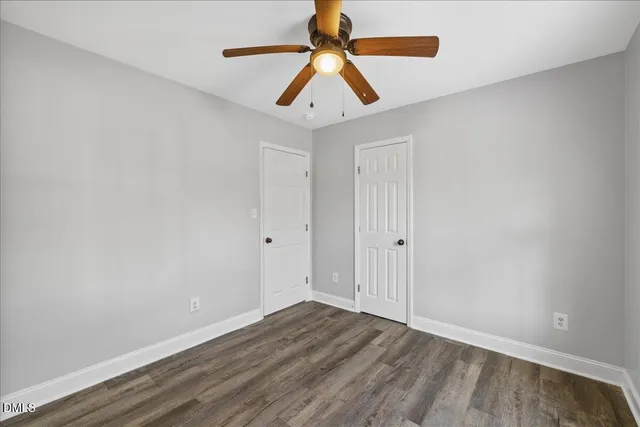 an empty room with window and ceiling fan