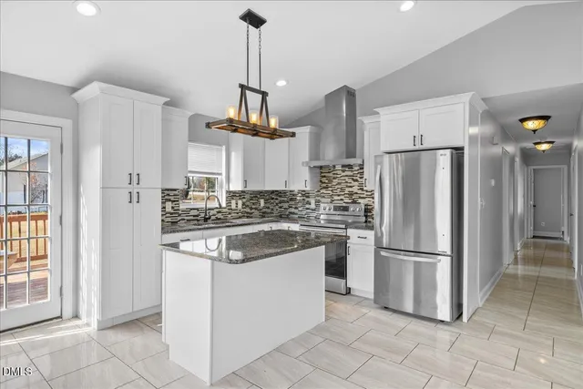 a kitchen with stainless steel appliances granite countertop a refrigerator a sink and a stove