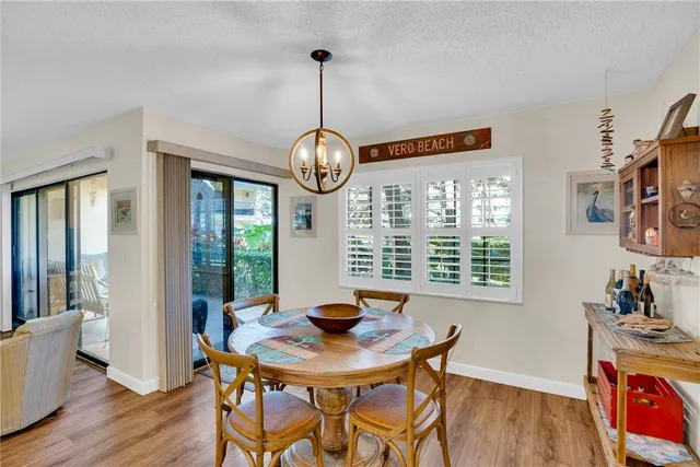 a view of a dining room with furniture a chandelier and wooden floor