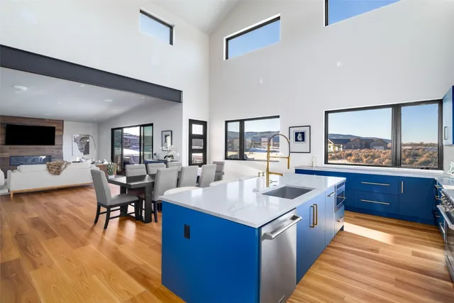 a kitchen with a dining table chairs and flat screen tv