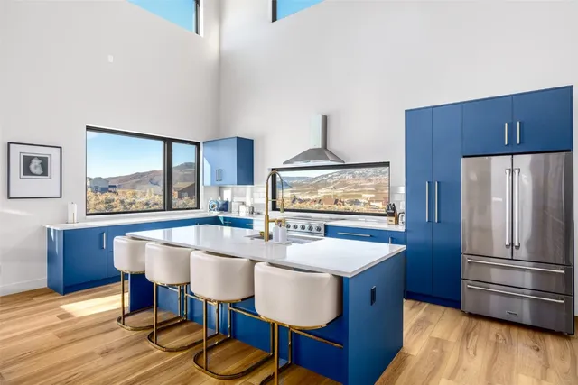 a kitchen with stainless steel appliances a dining table chairs and wooden floor
