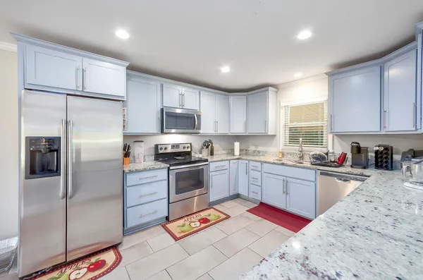 a kitchen with stainless steel appliances granite countertop a refrigerator sink and microwave