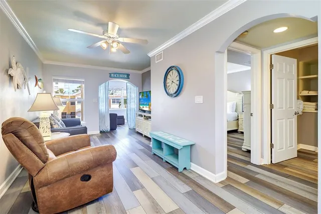 a living room with furniture a chandelier fan and a window