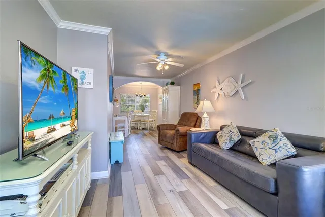 a living room with furniture a flat screen tv and a large window