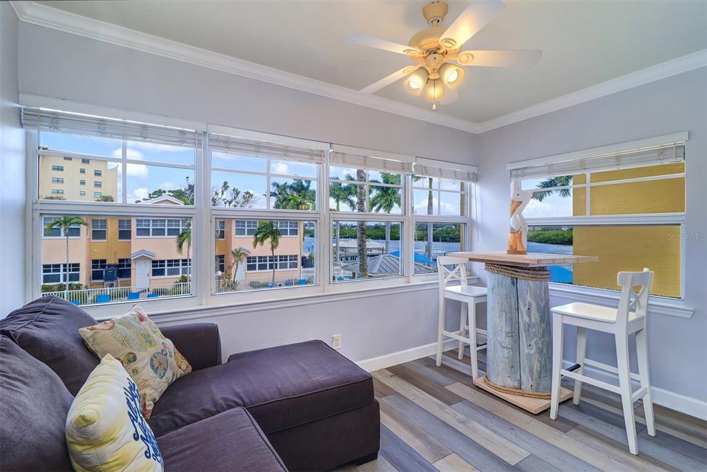 19417 Gulf Boulevard, Unit A202 Indian Shores, FL 33785 - Photo 19 of 35 a living room with furniture a flat screen tv and a large window