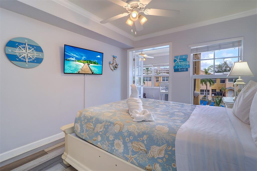 19417 Gulf Boulevard, Unit A202 Indian Shores, FL 33785 - Photo 23 of 35 a bedroom with a bed and a chandelier