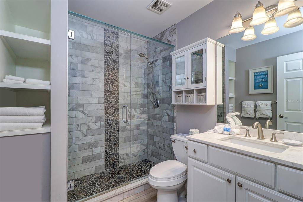 19417 Gulf Boulevard, Unit A202 Indian Shores, FL 33785 - Photo 25 of 35 a bathroom with a sink a toilet and shower