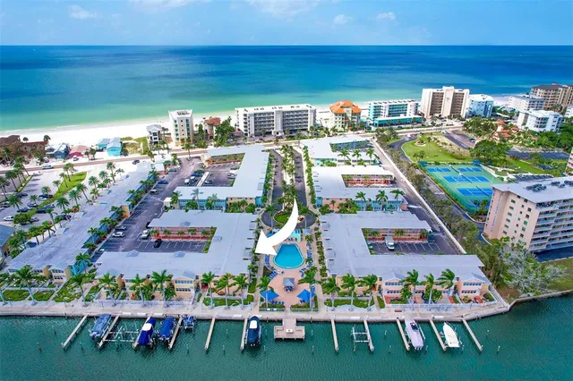 an aerial view of a city with lots of residential buildings ocean and mountain view in back
