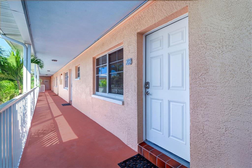 19417 Gulf Boulevard, Unit A202 Indian Shores, FL 33785 - Photo 4 of 35 a hallway with wooden floor and windows