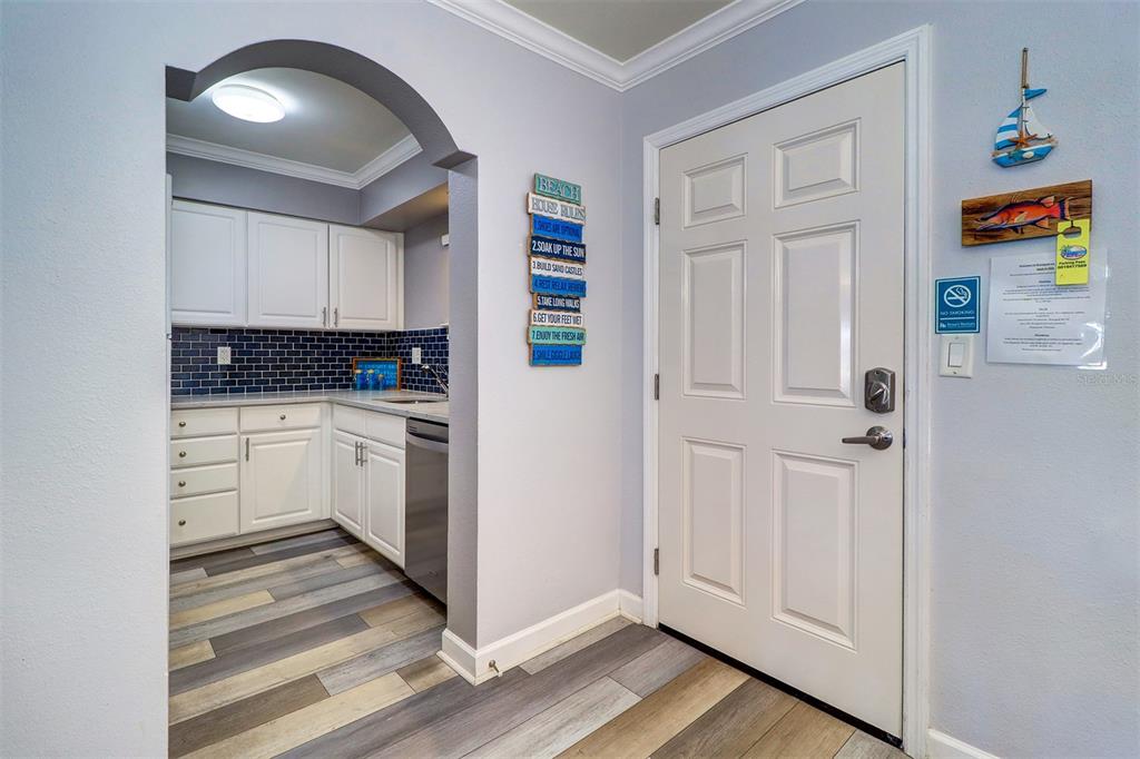 19417 Gulf Boulevard, Unit A202 Indian Shores, FL 33785 - Photo 5 of 35 a kitchen with white cabinets and white appliances