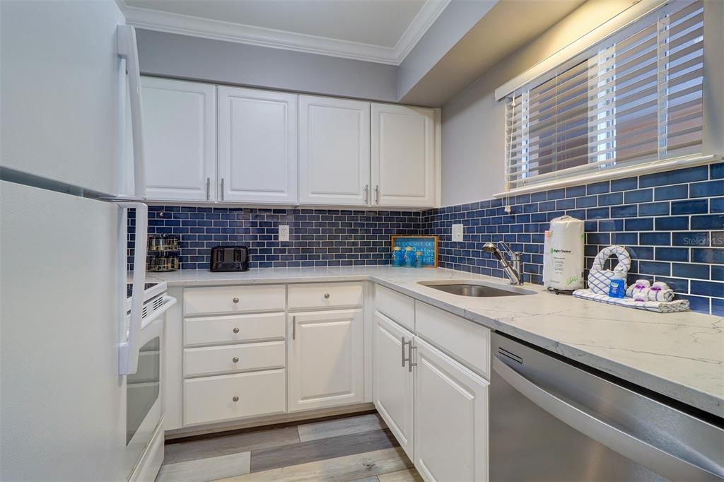 19417 Gulf Boulevard, Unit A202 Indian Shores, FL 33785 - Photo 6 of 35 a kitchen with white cabinets and sink