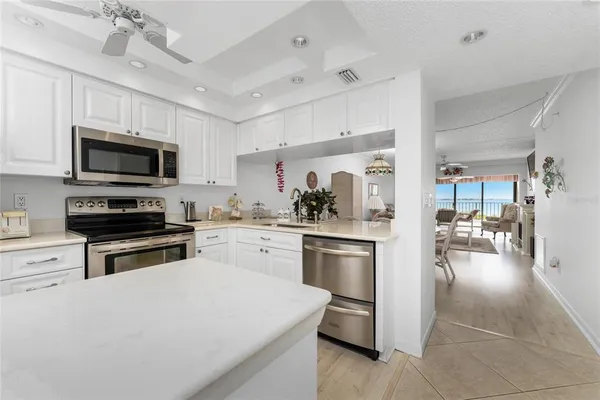 a kitchen with granite countertop a stove cabinets and refrigerator
