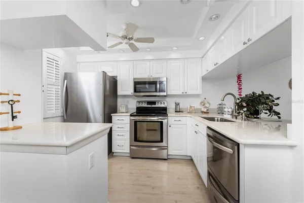 a kitchen with granite countertop a sink stove and refrigerator