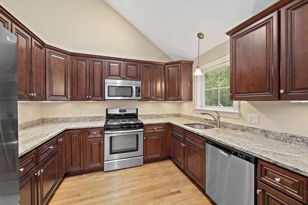 14 Sugar Maple Circle, Unit 14 Hanover, MA 02339 - Photo 4 of 38 a kitchen with stainless steel appliances granite countertop wooden cabinets a stove top oven a sink and dishwasher
