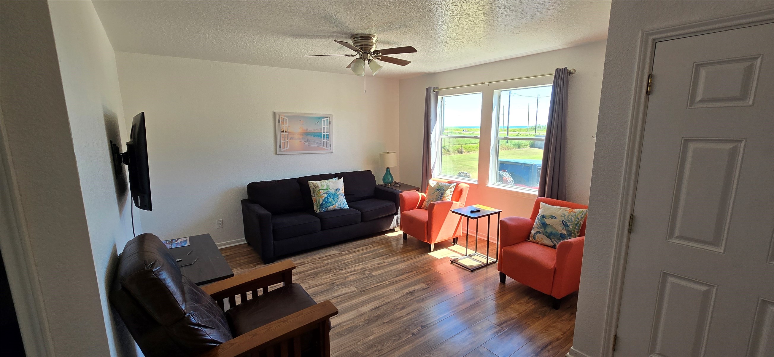 16506 Blackbeard Road, Unit E Jamaica Beach, TX 77554 - Photo 2 of 10 a living room with furniture and wooden floor
