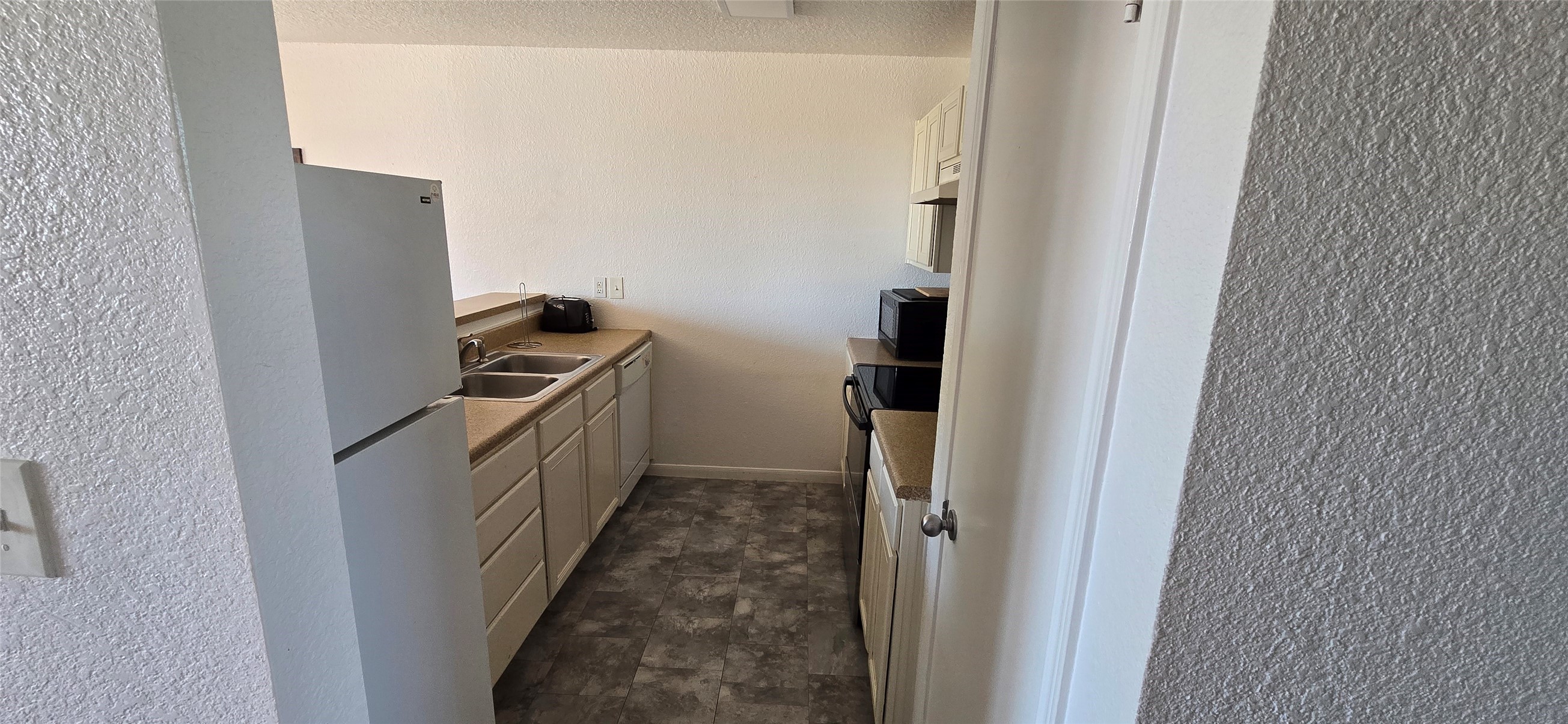 16506 Blackbeard Road, Unit E Jamaica Beach, TX 77554 - Photo 4 of 10 a kitchen with a refrigerator and a stove