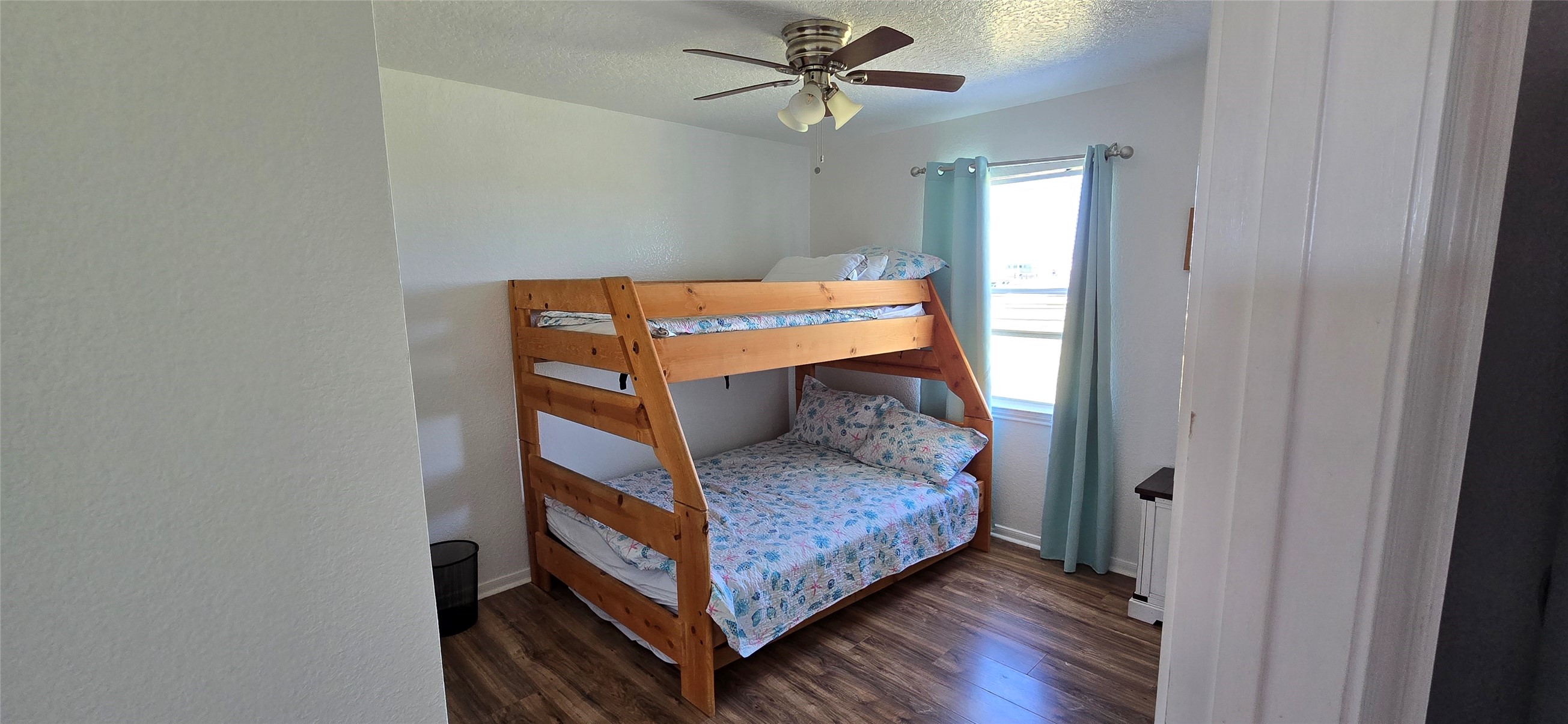 16506 Blackbeard Road, Unit E Jamaica Beach, TX 77554 - Photo 5 of 10 a bedroom with a bed and a chandelier