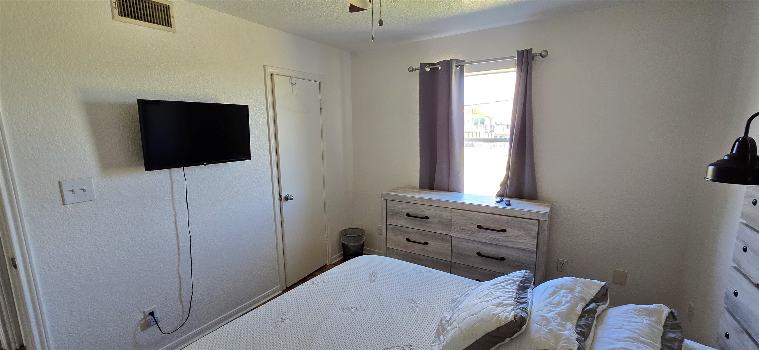 16506 Blackbeard Road, Unit E Jamaica Beach, TX 77554 - Photo 10 of 10 a bedroom with a bed and a flat tv screen on the dresser