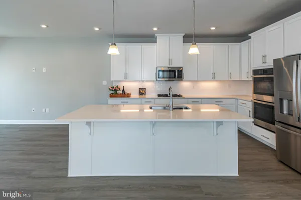a kitchen with kitchen island a sink stainless steel appliances and cabinets