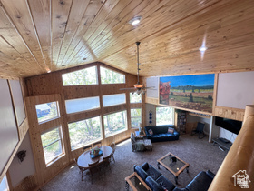 1940 East Shore Road St. Charles, ID 83272 - Photo 20 of 64 Living room featuring wooden walls, carpet floors, ceiling fan, and a vaulted wood ceiling