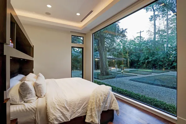 a bed sitting in a spacious bedroom next to a yard