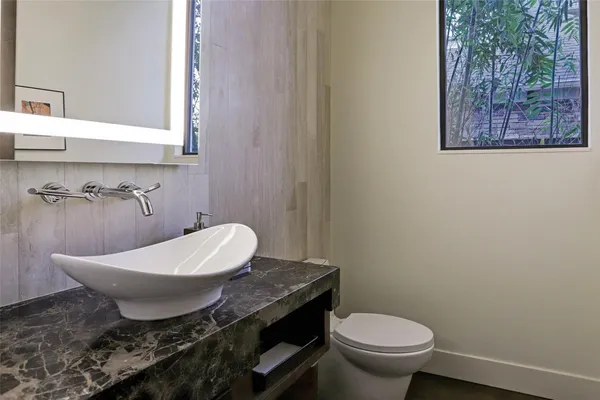 a bedroom with a bed and a large mirror with potted plant