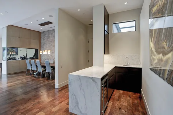 a kitchen with stainless steel appliances kitchen island granite countertop a refrigerator a stove and a dining table with wooden floor