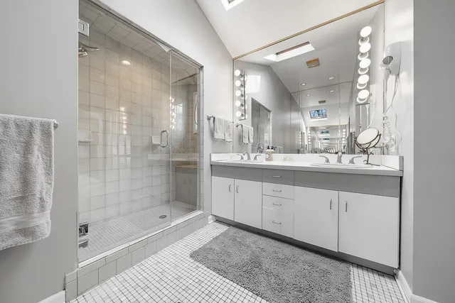 a bathroom with a shower a sink and a mirror