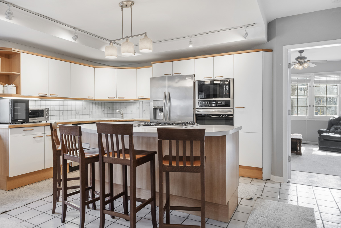515 Maple Avenue Wilmette, IL 60091 - Photo 8 of 26 a kitchen with granite countertop a table chairs microwave and refrigerator