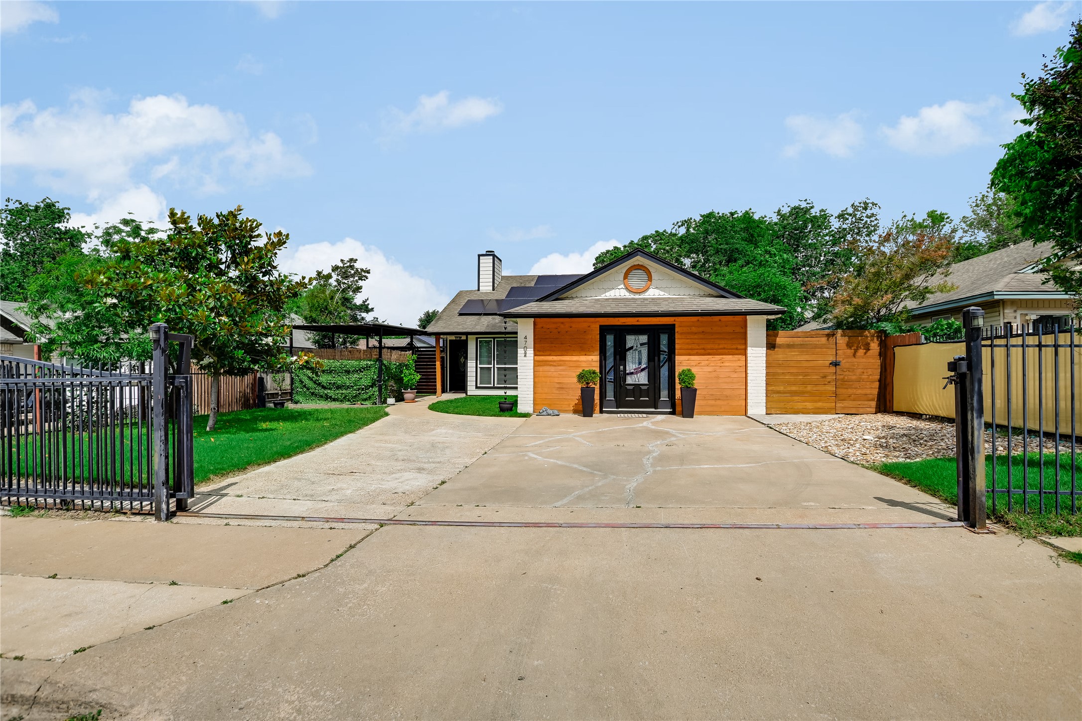 Wood-sided exterior with a central entry door and a circular window accent