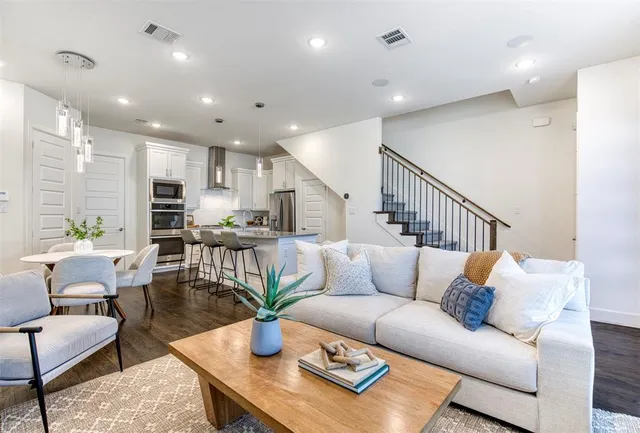 a living room with furniture kitchen view and a potted plant