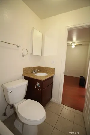 a bathroom with a granite countertop sink a toilet and shower