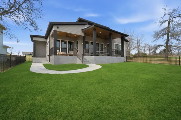 a view of a green field with a lake in the background