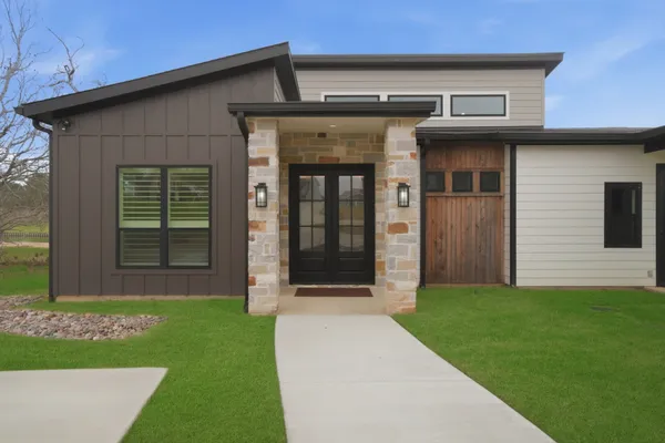 a kitchen with stainless steel appliances kitchen island granite countertop a table chairs in it and wooden floors