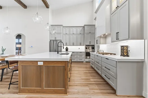 a dining hall with stainless steel appliances kitchen island granite countertop a table chairs and a refrigerator