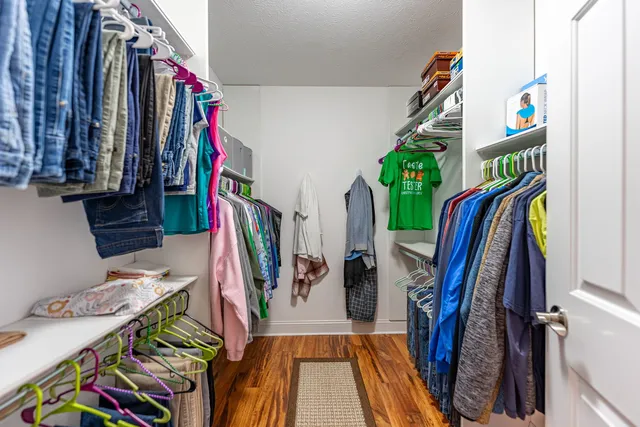 a view of walk in closet with clothes and shoes