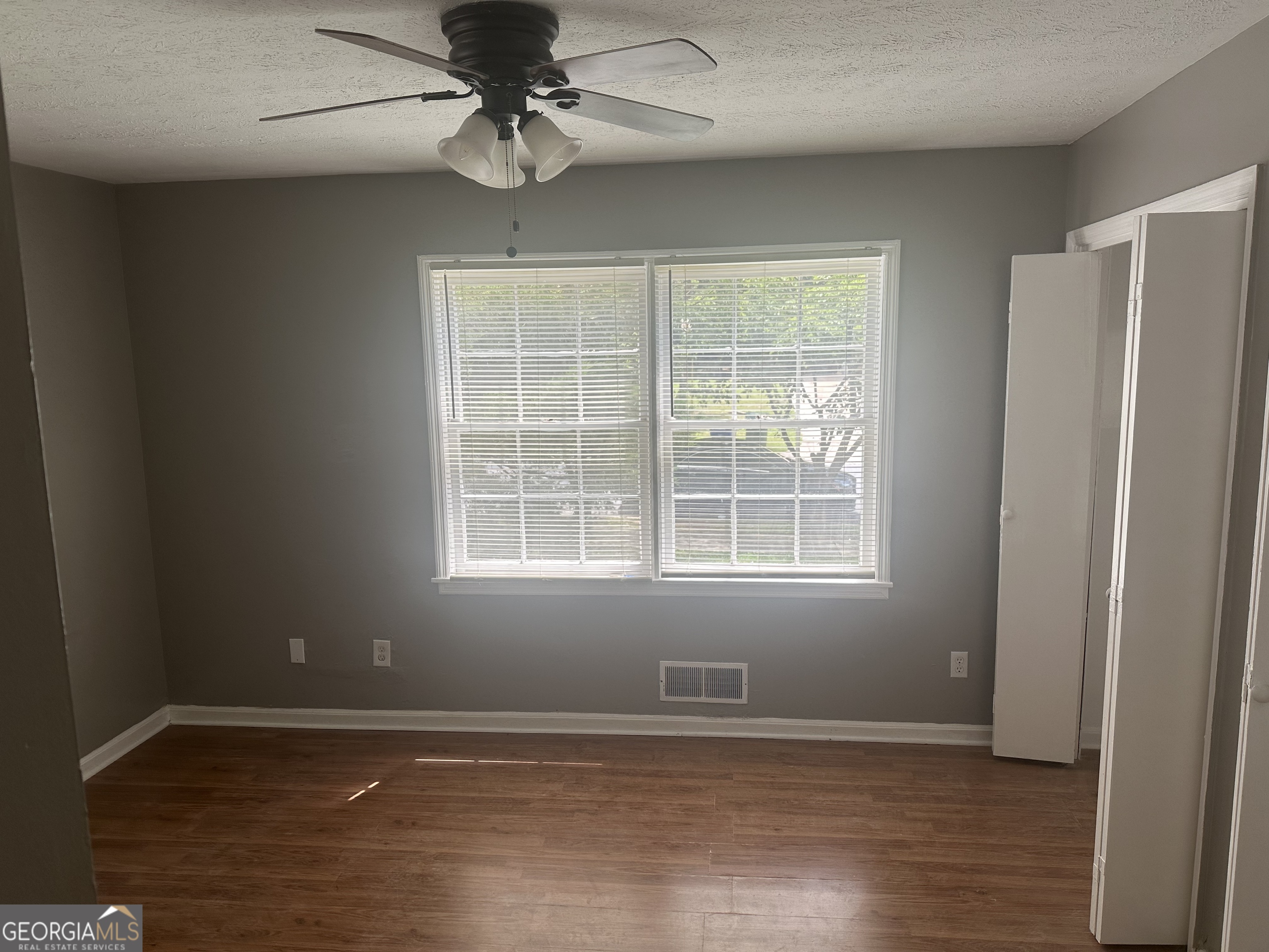 273 Fennel Way Southwest Atlanta, GA 30331 - Photo 12 of 20 an empty room with wooden floor fan and windows