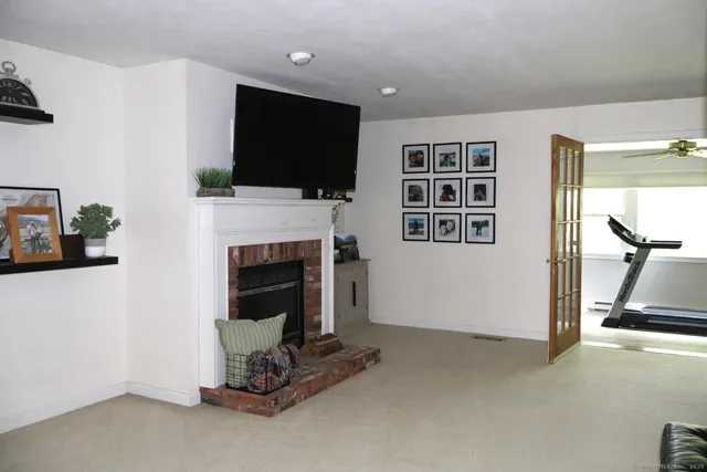 a living room with furniture a flat screen tv and a fireplace