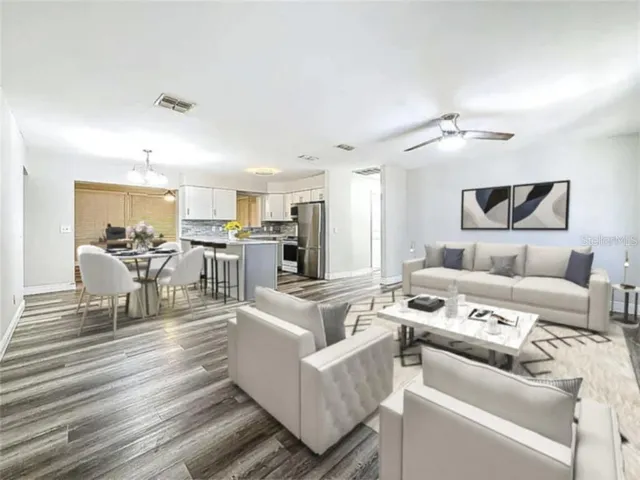 a living room with furniture and a view of kitchen