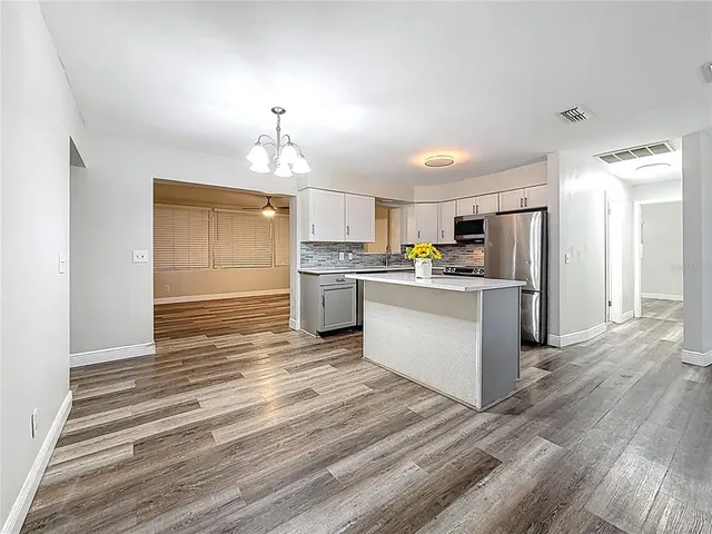 a kitchen with a refrigerator and a stove top oven
