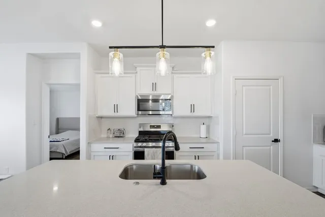 a kitchen with kitchen island a sink appliances and cabinets