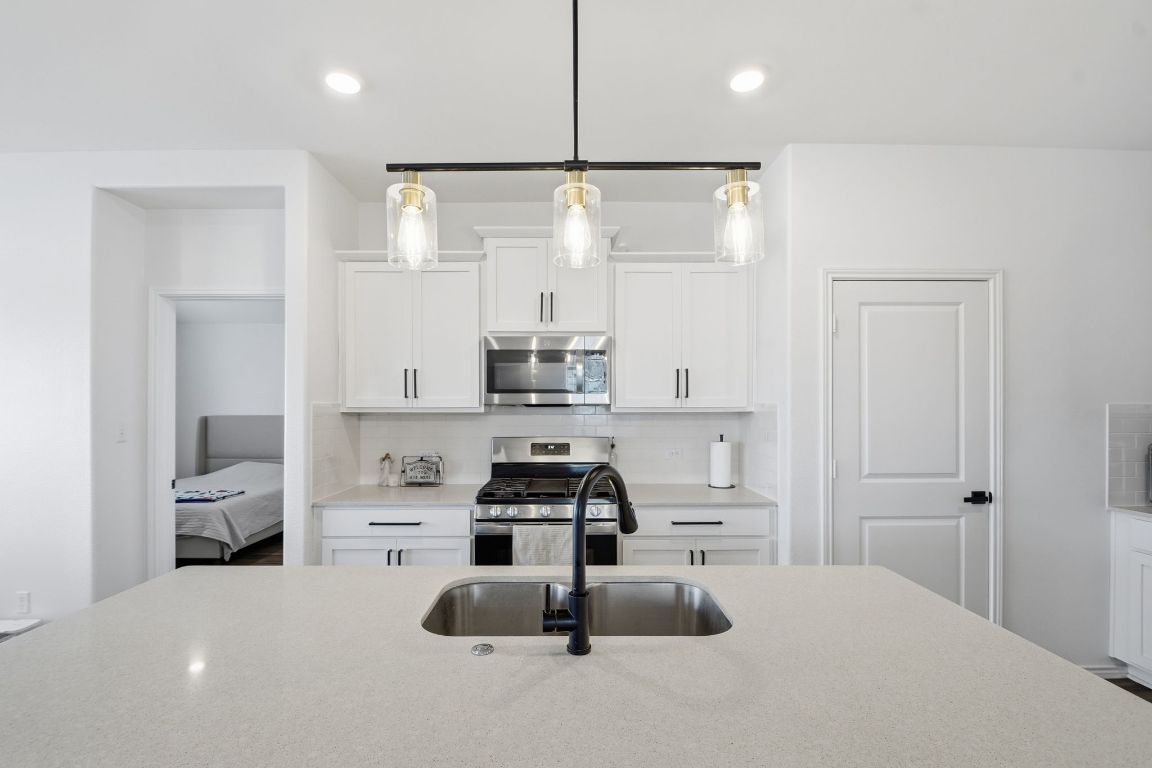 287 George Neggan Lane Bastrop, TX 78602 - Photo 11 of 26 a kitchen with kitchen island a sink appliances and cabinets