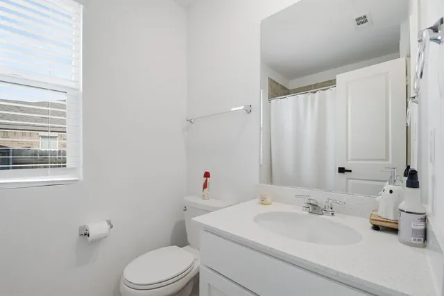 a bathroom with a sink a toilet and shower curtain