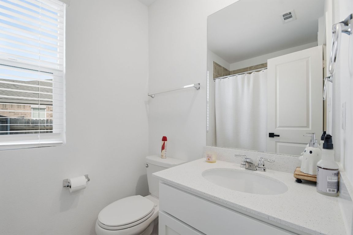 287 George Neggan Lane Bastrop, TX 78602 - Photo 14 of 26 a bathroom with a sink a toilet and shower curtain