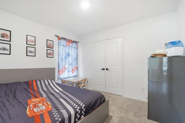 a bedroom with a bed and a painting on the wall