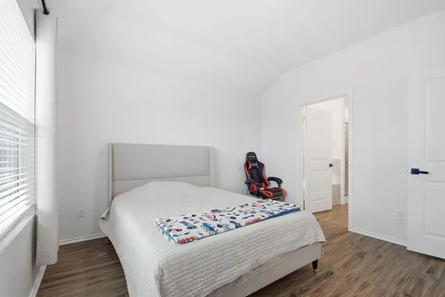 a bedroom with a bed and a window