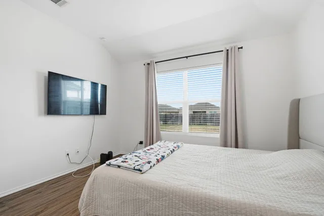 a bedroom with a large bed and a window